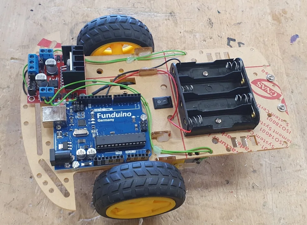 Frühe fahrbare Prototypplattform mit Funduino, Motortreiber, Batteriehalter und zwei großen Rädern